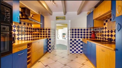 een keuken met blauwe kasten en een geruite muur bij Belle maison avec piscine privée in Saint-Pierre-Quiberon