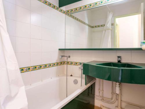 La salle de bains est pourvue d'un lavabo vert et d'une baignoire. dans l'établissement Studio Moderne avec Piscine, Parc Naturel près de la Corniche à Hendaye - FR-1-2-303, à Urrugne