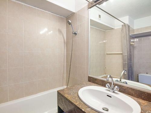 une salle de bain avec un lavabo, une baignoire et un miroir dans l'établissement Appartement rustique avec piscine près du port et plage - FR-1-2-284, à Hendaye