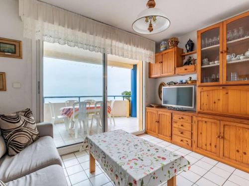 un salon avec un canapé, une table et une télévision dans l'établissement Appartement Rustique Face à la Mer à Hendaye avec Balcon - FR-1-2-294, à Hendaye