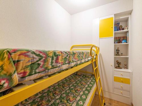 Ce lit superposé jaune se trouve dans un dortoir doté d'une étagère. dans l'établissement Appartement Rustique Face à la Mer à Hendaye avec Balcon - FR-1-2-294, à Hendaye