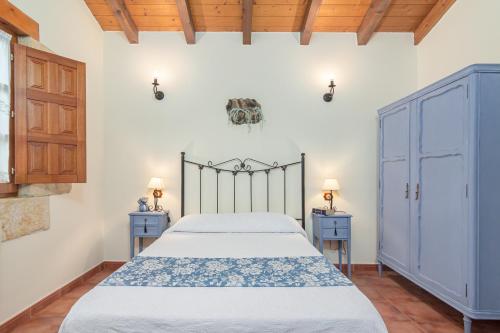 ein Schlafzimmer mit einem Bett und zwei blauen Schränken in der Unterkunft El rincón de Lalo in Prases