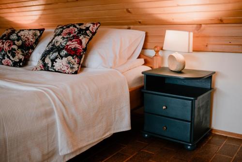 ein Schlafzimmer mit einem Bett und einem Nachttisch mit einer Lampe in der Unterkunft Agroturystyka u Marleny in Skorzenno