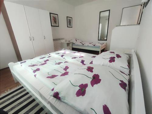 een slaapkamer met een bed met paarse bloemen erop bij M&R apartmani Rovinj in Rovinj