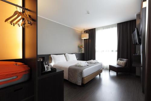 a hotel room with a bed and a window at Best Western Premier CHC Airport in Genova