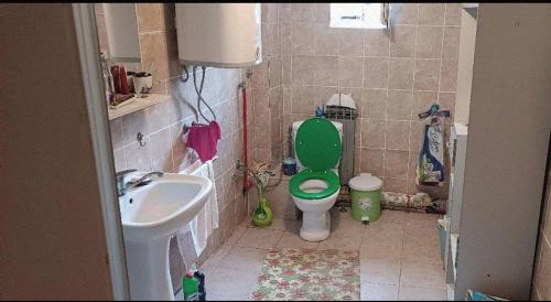 a bathroom with a green toilet and a sink at Happy Home in Starčevo