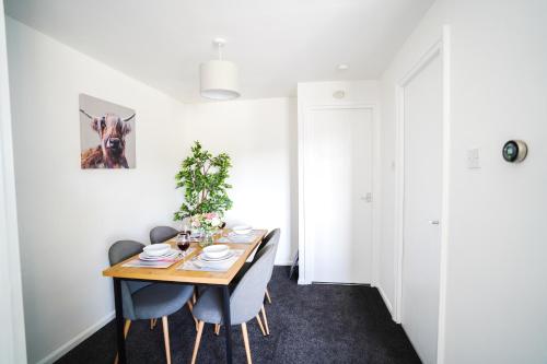 a dining room with a wooden table and blue chairs at Gayton Apt, 2 BR, Sleeps 4, FREE parking, Kitchen, Close Motorways in Doncaster