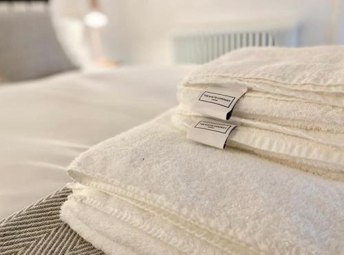 a stack of white towels sitting on top of a bed at The Old Chapel Manton in Manton