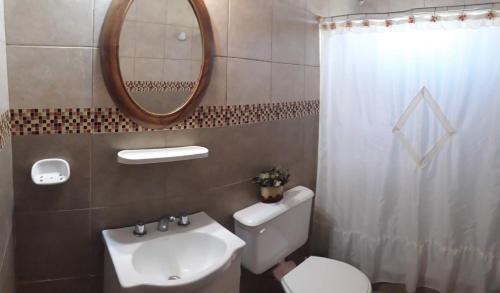 a bathroom with a toilet and a sink and a mirror at Lugar de PAZ en las Sierras in Sierra de la Ventana