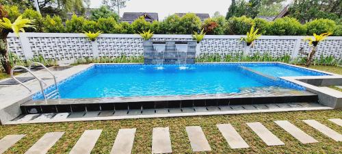 a swimming pool in a yard next to a white fence at SF Homey Yokohama in Cikundul
