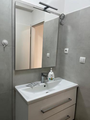 ein Badezimmer mit einem weißen Waschbecken und einem Spiegel in der Unterkunft Apartment Renata in Zadar