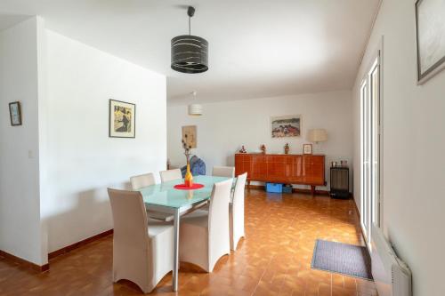 une salle à manger avec une table en verre et des chaises blanches dans l'établissement Maison confortable à Vendres, 87 m², proche plage, à Vendres