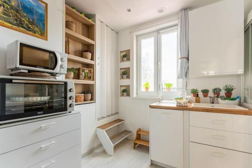 a kitchen with white cabinets and a microwave at Casa Inca Calais - Duplex Soleil Latino - Parking Free, Station in Calais