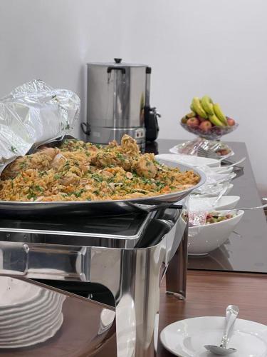 a table with a pan of food on a counter at Petra Family Hotel in Wadi Musa