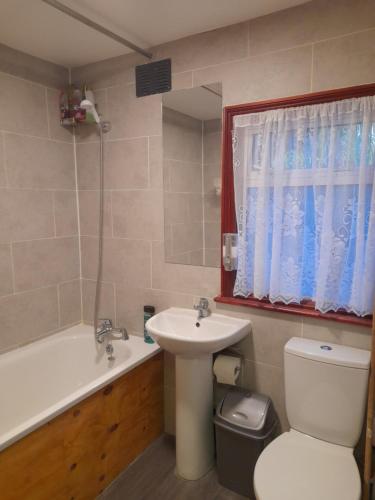 a bathroom with a sink and a toilet and a tub at Bubblesbnb- 4 Bedroom House in London