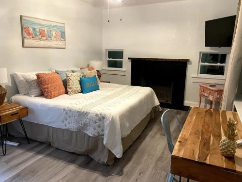 a bedroom with a bed with pillows and a fireplace at 5 bed 4 bath pool table fire pit walk to beach in Daytona Beach