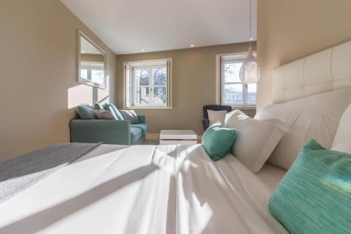 a bedroom with a large white bed and a couch at Oporto Near Clérigos in Porto