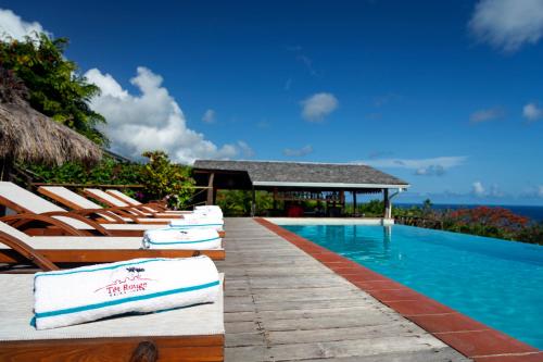 a row of lounge chairs next to a swimming pool at Tet Rouge Resort in Soufrière