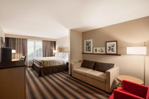 ボーズマンにあるCountry Inn & Suites by Radisson, Bozeman, MTのベッドとソファ付きのホテルルーム