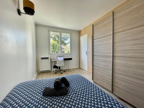Schlafzimmer mit einem Bett, einem Schreibtisch und einem Fenster in der Unterkunft Superbe appartement dans une résidence avec garage - 137 in Bihorel