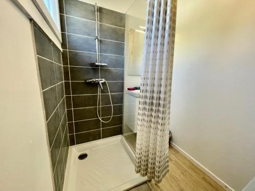 y baño con ducha y cortina de ducha. en Superbe appartement dans une résidence avec garage - 137, en Bihorel