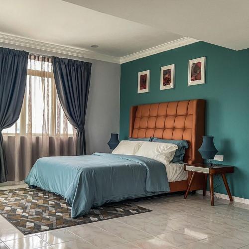 a bedroom with a large bed with blue walls at The Penthouse in Kuah