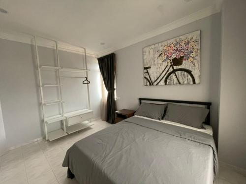 a bedroom with a bed and a painting on the wall at The Penthouse in Kuah