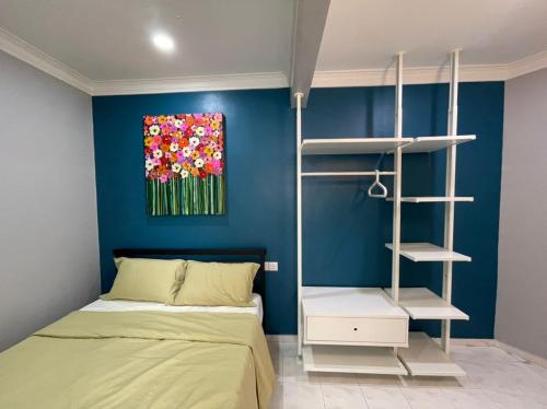 a bedroom with a bed and a painting of flowers at The Penthouse in Kuah