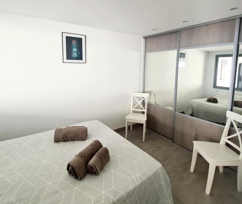 une chambre blanche avec un lit et un miroir dans l'établissement MAGNIFIQUE APPARTEMENT VUE MER - GRANDE TERRASSE ET PISCINE, à Bandol