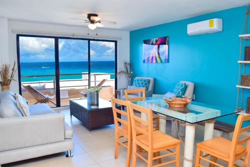 a living room with a table and chairs and the ocean at Ocean view apartment, best beach area, 3 bedrooms in Cancún