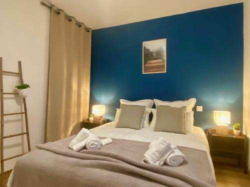 1 dormitorio con 1 cama grande y toallas. en Le Point Virgule - Parking Privé - Climatisation, en Montauban