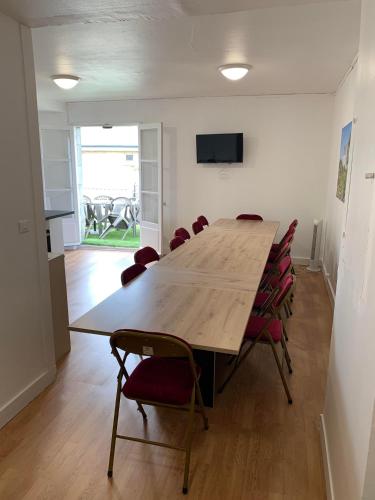 une salle de conférence avec une grande table et des chaises en bois dans l'établissement Logement de groupe à Villandry avec terrasse, à Villandry