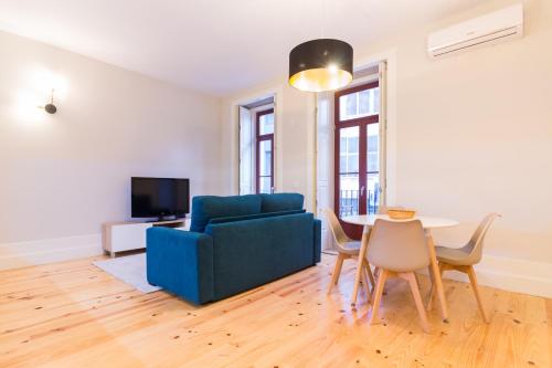 een woonkamer met een blauwe bank en een tafel bij Oporto Near Coliseu in Porto