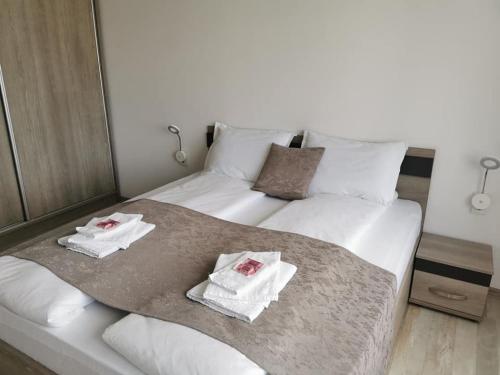 a large white bed with towels on top of it at Апартамент Time for us in Velingrad