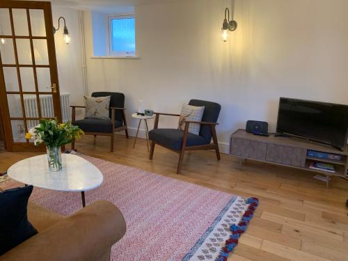 a living room with a couch and chairs and a tv at The Old Chapel Manton 