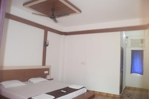 1 dormitorio con 1 cama y ventilador de techo en Hotel Exotica Squares en Neil Island