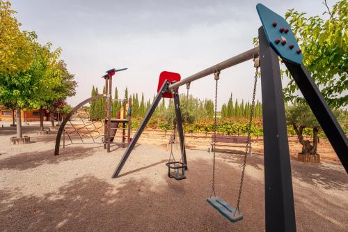 une aire de jeux vide avec balançoires et toboggan dans l'établissement Bodega Andrés Iniesta con visita y cata, à Fuentealbilla