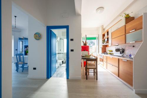 a kitchen with a blue door and a dining room at Casa Roberta in Maiori