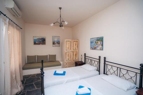 a bedroom with two beds and a couch at Giannakas Studios in Platis Yialos Sifnos