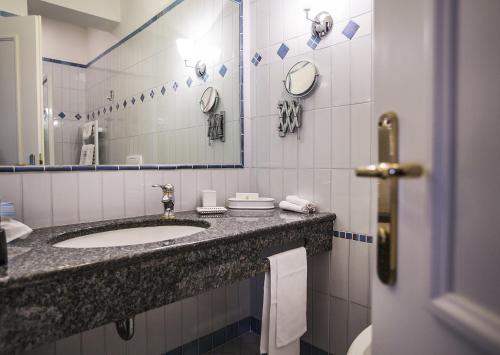 a bathroom with a sink and a mirror at Regina Adelaide Hotel & SPA in Garda