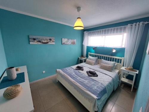 a blue bedroom with a bed and a window at Apartamento Lily - FuerteventuraBay in Costa de Antigua