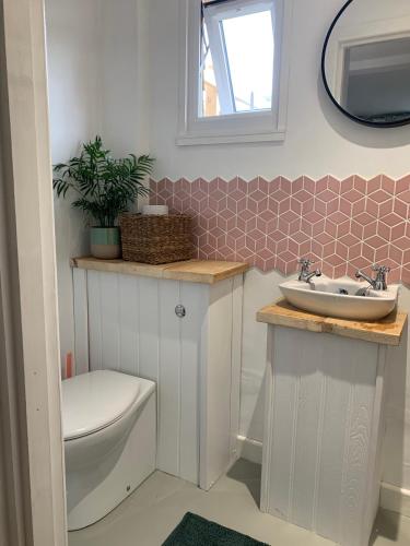 a bathroom with a sink and a toilet and a mirror at Seaside 1 Bed Studio Conversion in Selsey