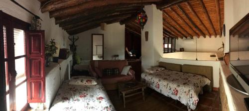 um quarto com duas camas e um sofá numa casa em Casa Bibiana em Posadilla