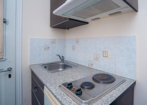 a kitchen with a sink and a stove at Giannakas Studios in Platis Yialos Sifnos