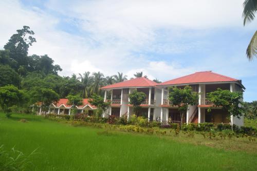 a row of houses in a field of grass at Hotel Exotica Squares in Neil Island