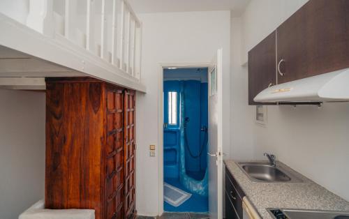 a bathroom with a sink and a blue shower at Giannakas Studios in Platis Yialos Sifnos