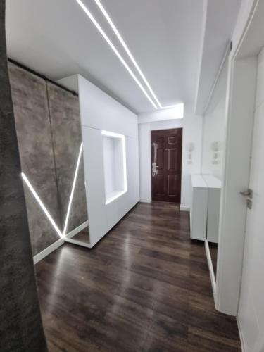 ein leeres Zimmer mit weißen Wänden und Holzboden in der Unterkunft Eclipsei ApartHotel in Popeşti-Leordeni