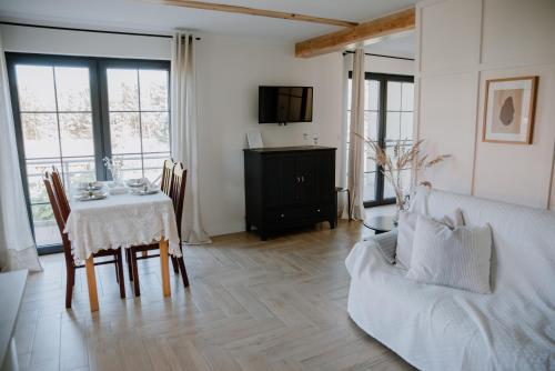 a living room with a table and a couch at Agroturystyka u Marleny in Skorzenno