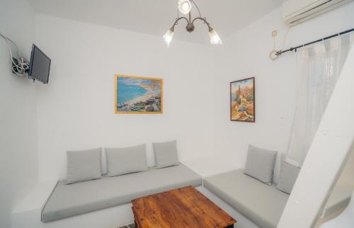 a white living room with a table and chairs at Giannakas Studios in Platis Yialos Sifnos