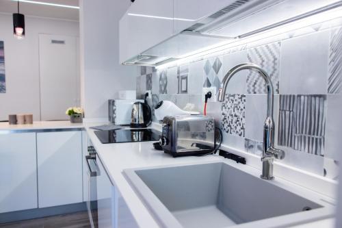 een witte keuken met een wastafel en een magnetron bij H11 [LUXURY SANREMO] Centro - Elegante - Casinò in Sanremo